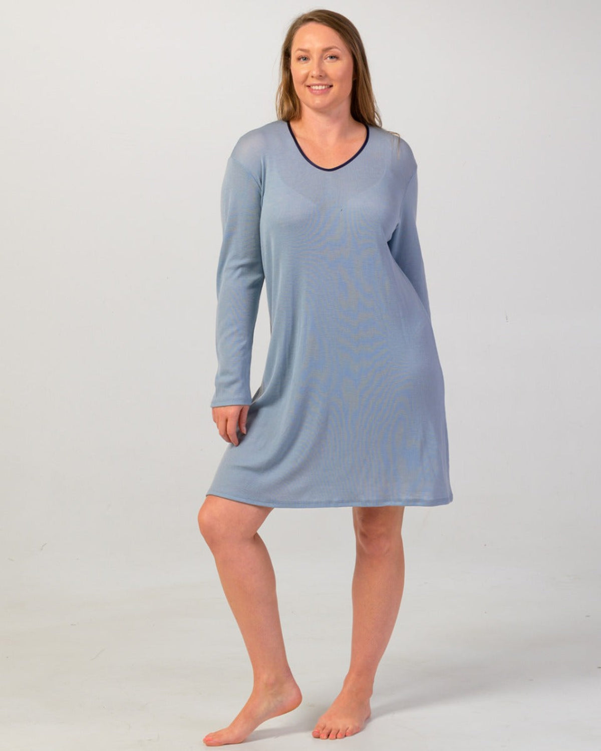 Woman wearing a blue nightshirt against a white background