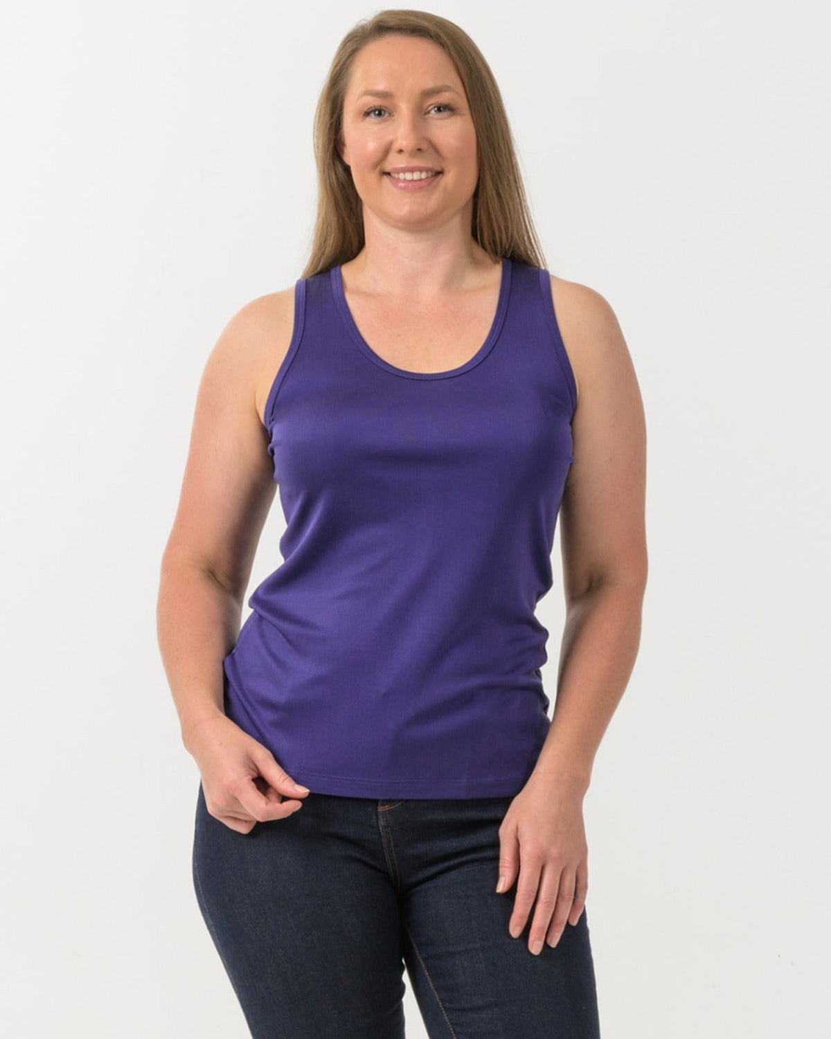 Woman wearing a silk  purple tank top against a white background
