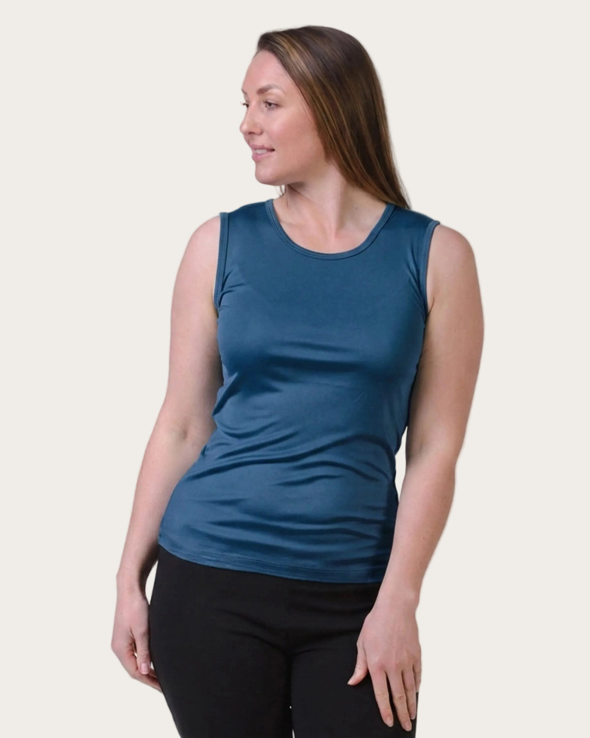 Woman wearing a silk blue sleeveless top on a white background