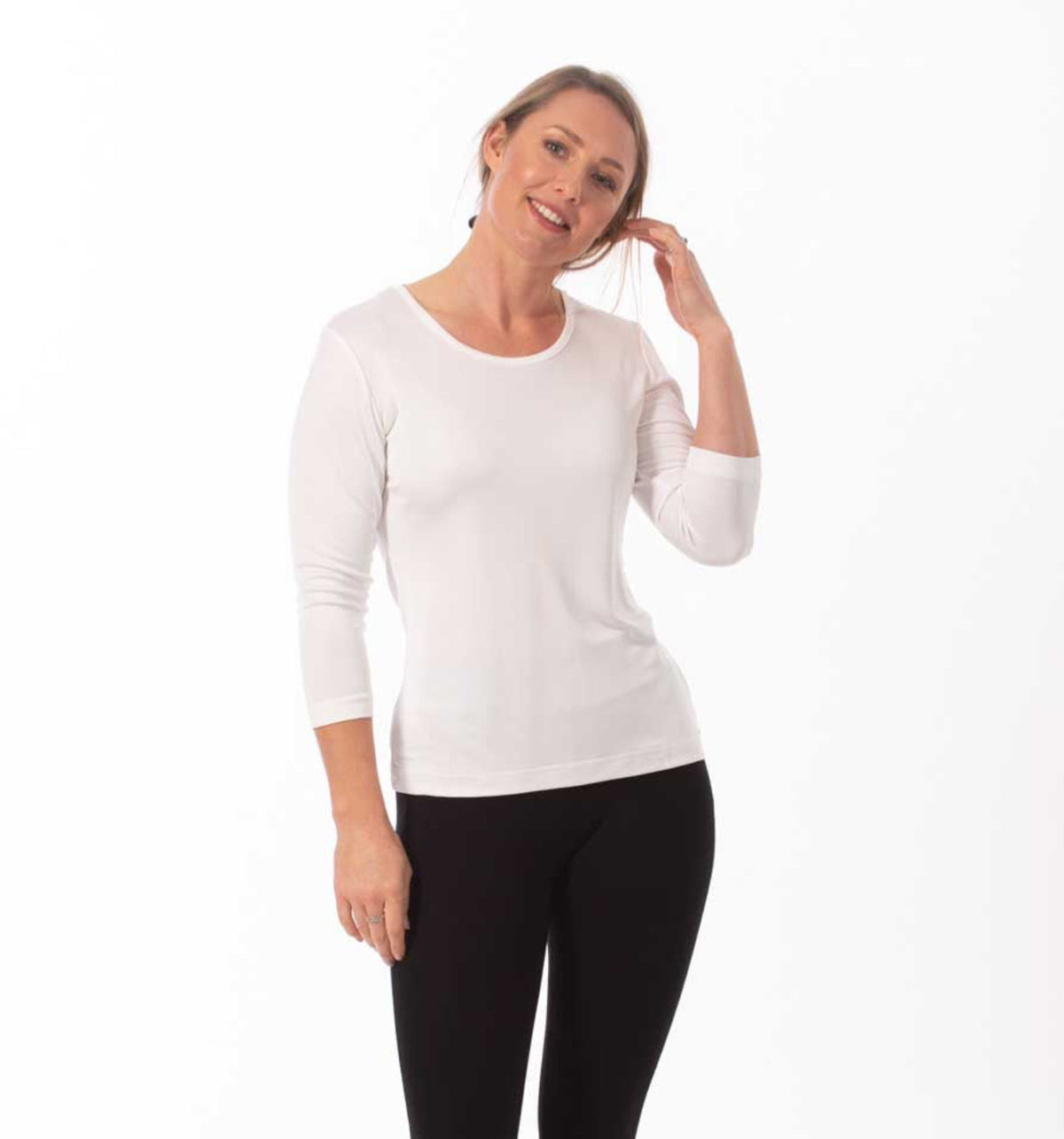 Woman wearing a silk white long-sleeve top and black pants on a white background
