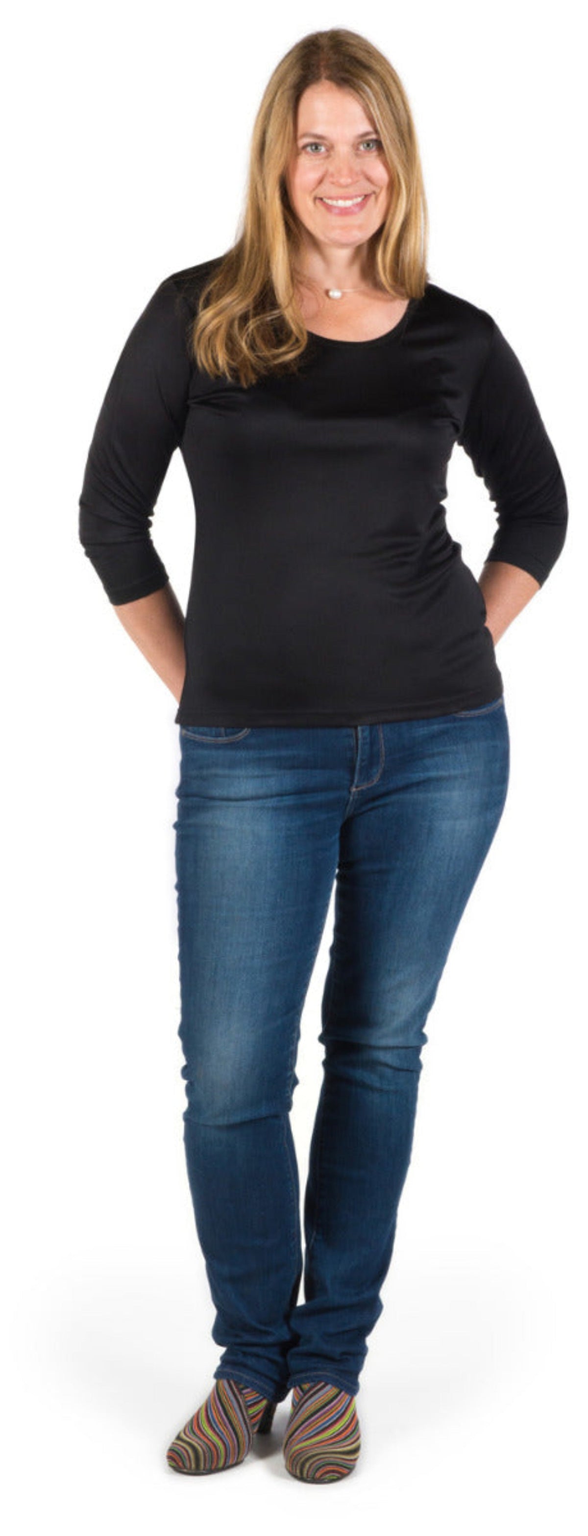 Woman wearing a silk black top and blue jeans on a white background