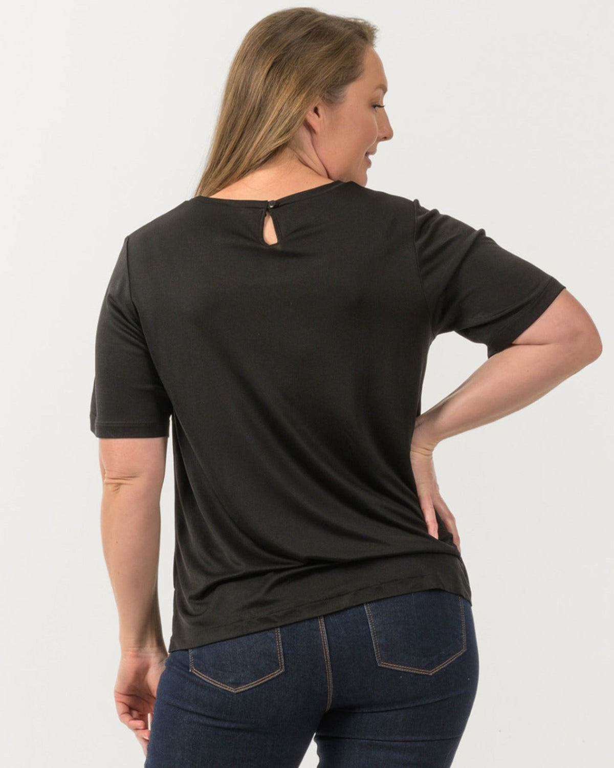 Woman wearing a silk black t-shirt with a cutout design on the back, 