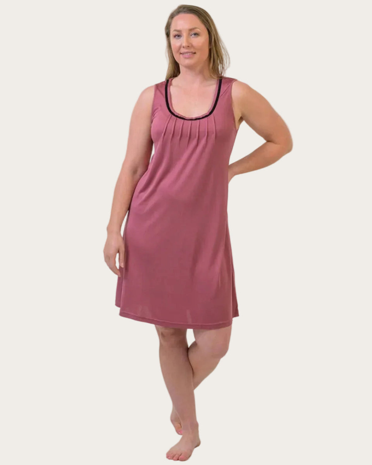 Woman wearing a silk pink 100% pure mulberry silk sleeveless nightie on a white background