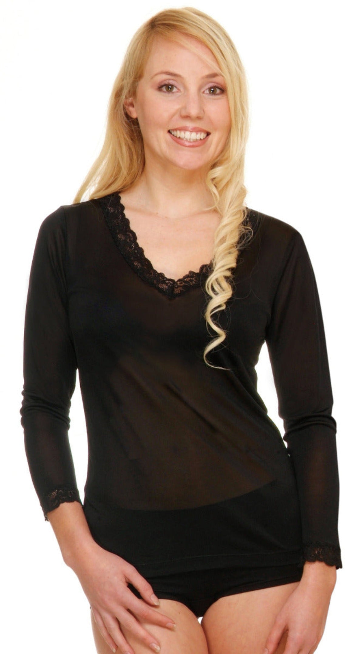 Woman wearing a silk black long-sleeve top with lace details on a white background