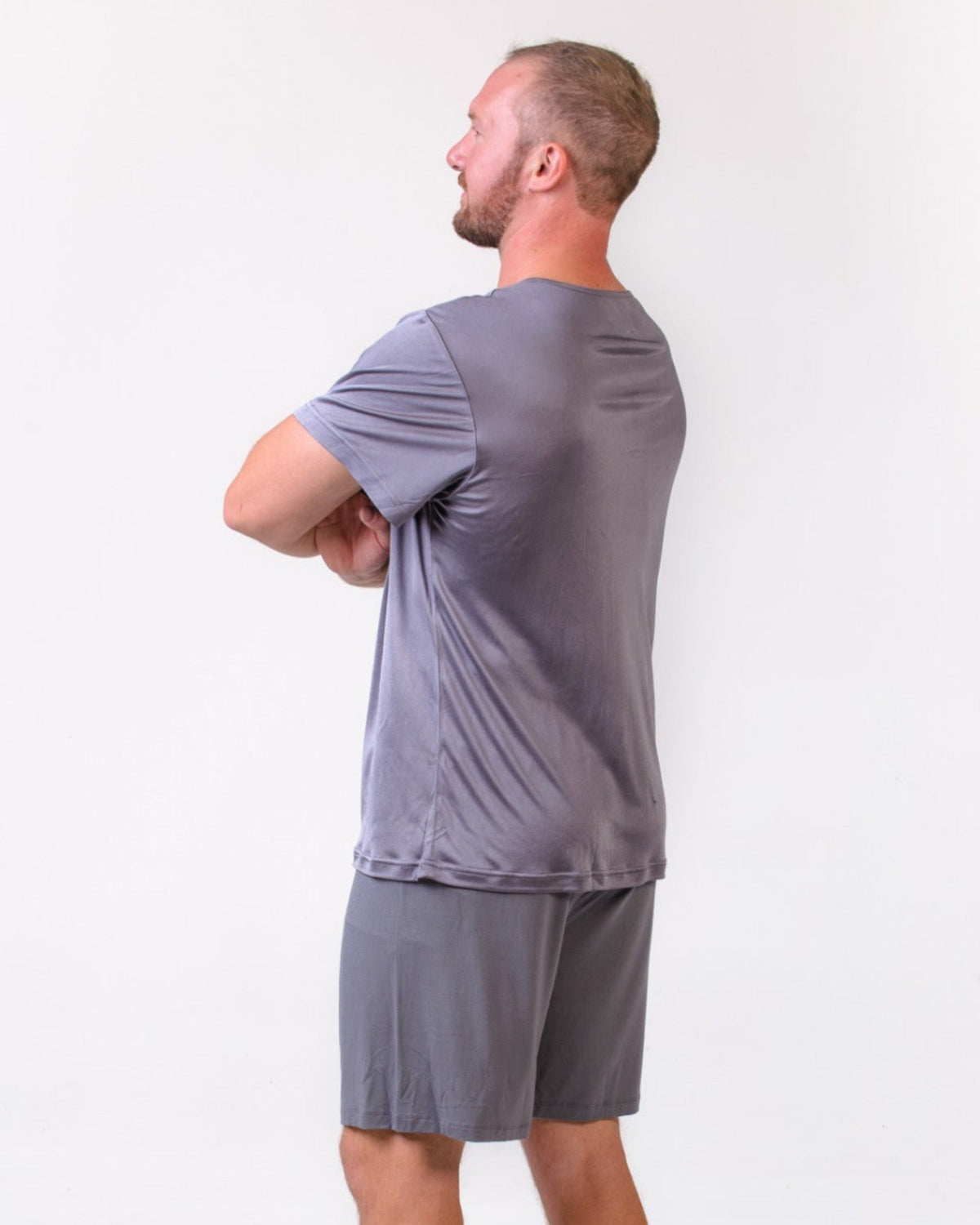 Man wearing a silk gray henley top and shorts 