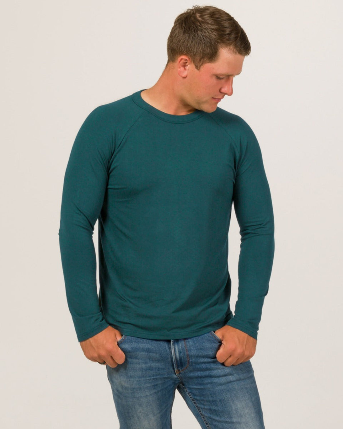 Bamboo Man wearing a teal long-sleeve shirt and blue jeans on a light gray background