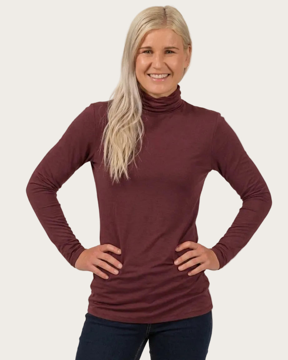 Woman bamboo  wearing a maroon turtleneck sweater against a plain background