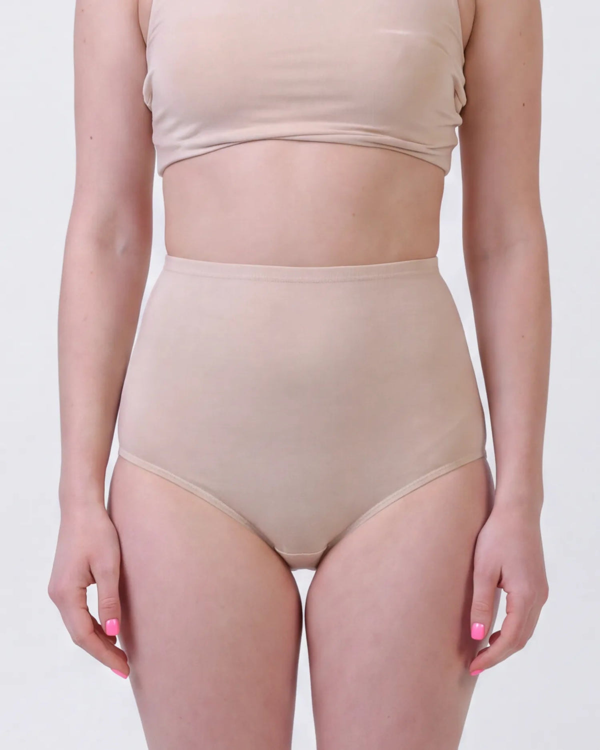 A model wearing a beige two-piece shapewear set consisting of a cropped tank top and high-waisted briefs, shown from the chest down against a plain light gray background.