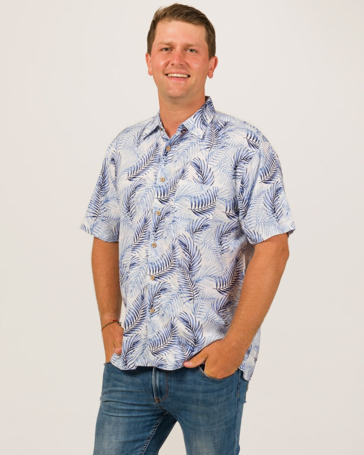 Man wearing a blue and white patterned shirt with short sleeves on a plain background
