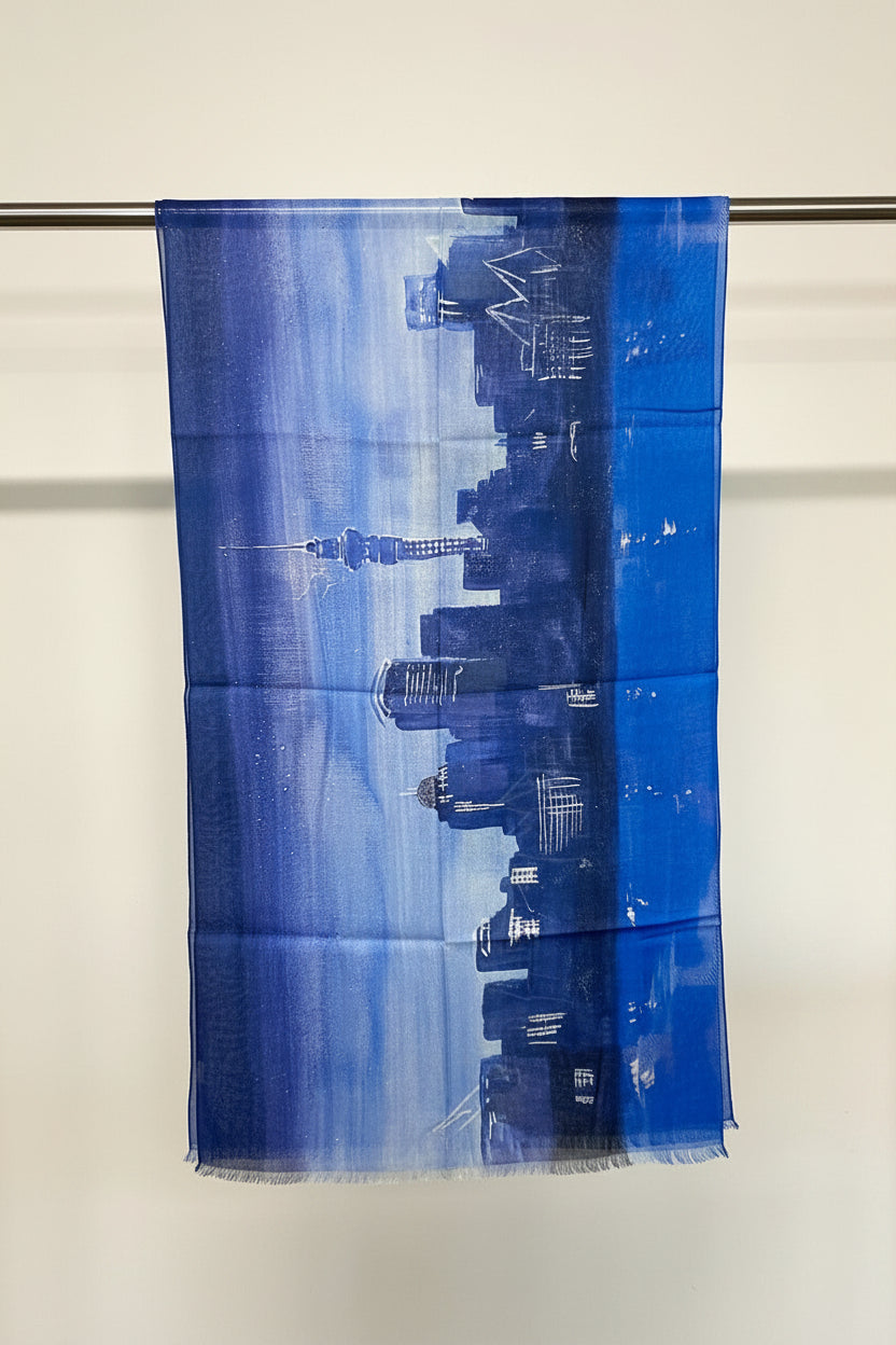 Blue fabric with a cityscape print hanging on a rod.