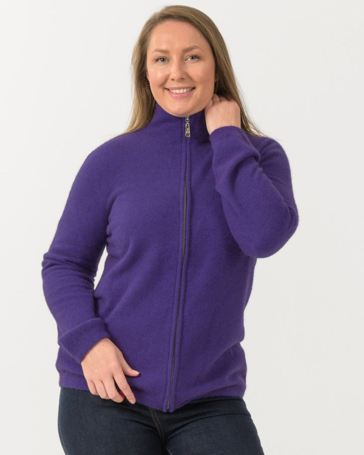 Woman wearing a purple possum merinozip-up sweatshirt on a white background