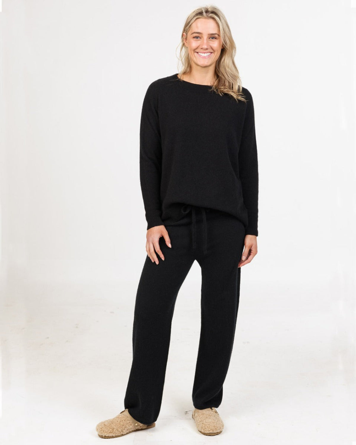 Woman wearing a black outfit Possum merino lounge pants