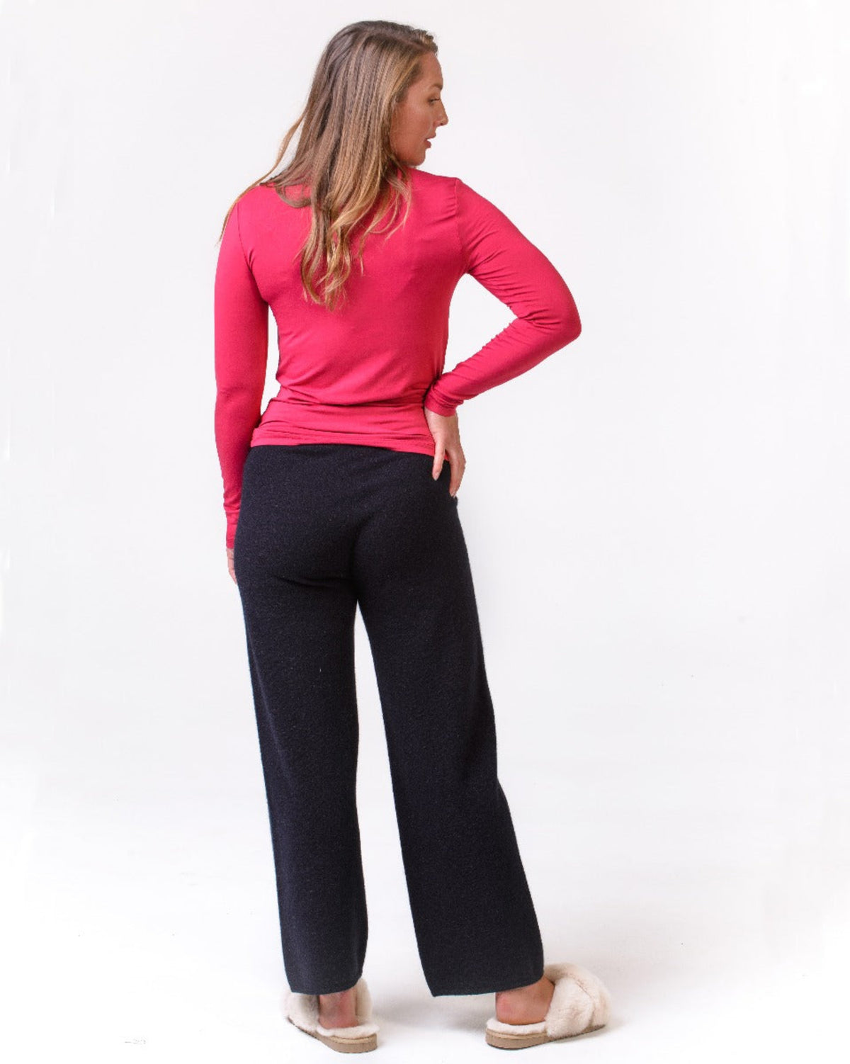 possum merino lounge Woman wearing a pink long-sleeve top and black pants on a white background