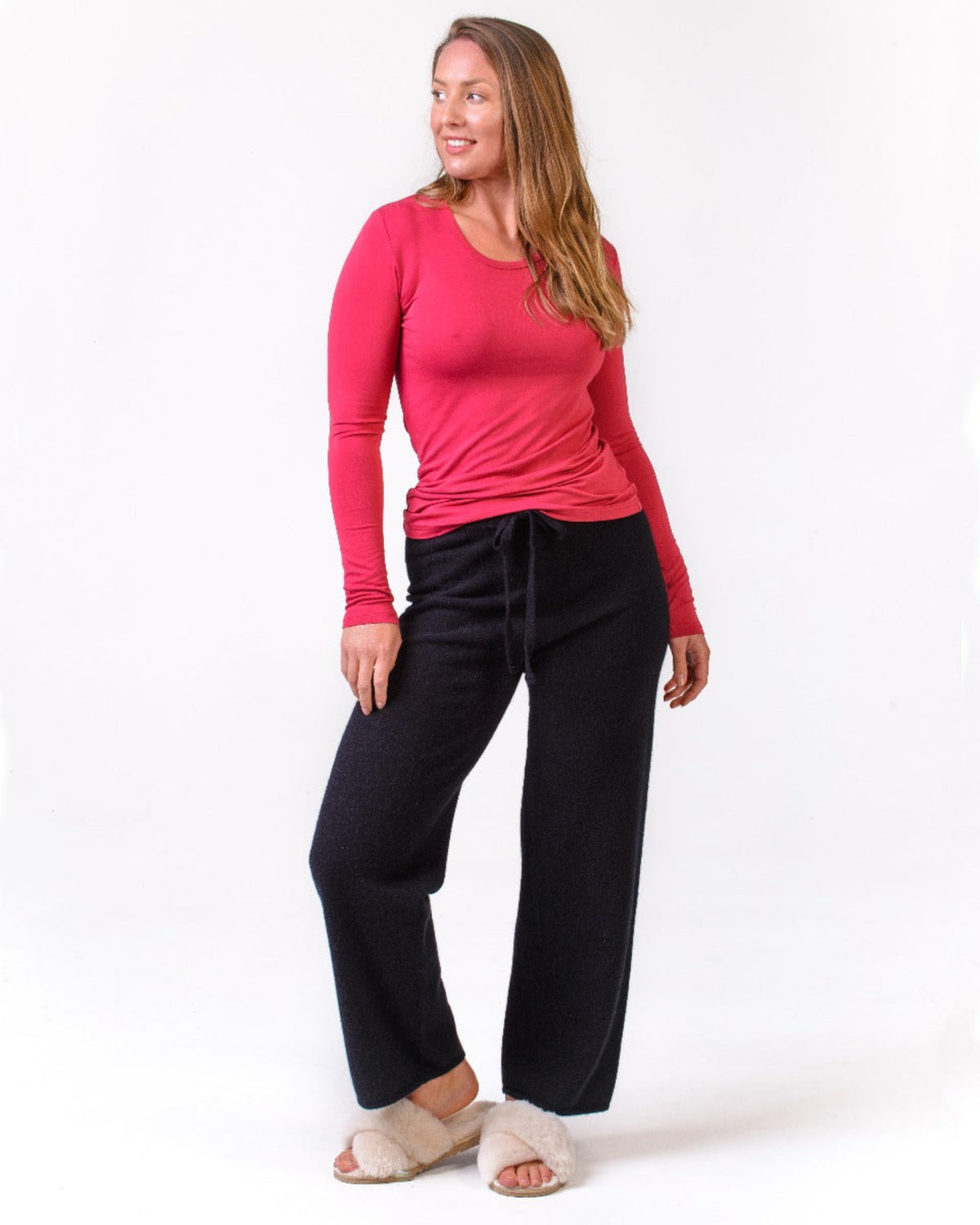 Possum merino lounge pants Woman wearing a pink long-sleeve top and black pants on a white background