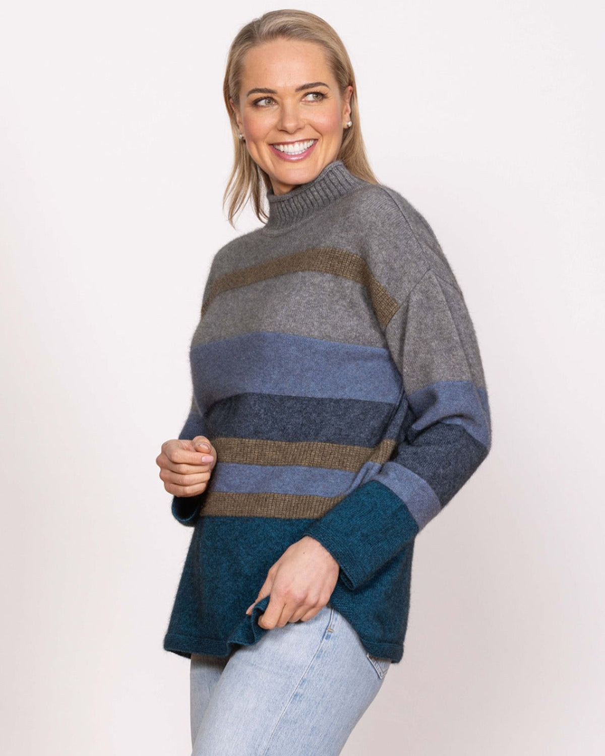 Possum merino Woman wearing a gray, blue, and brown striped sweater on a white background