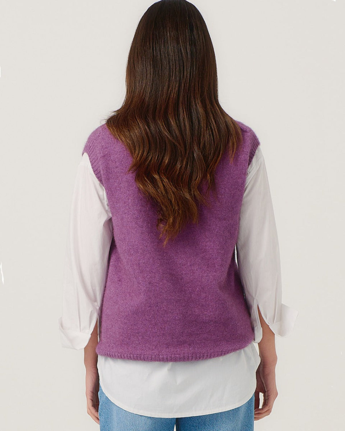 Possum Merino Person wearing a purple vest over a white shirt on a plain background
