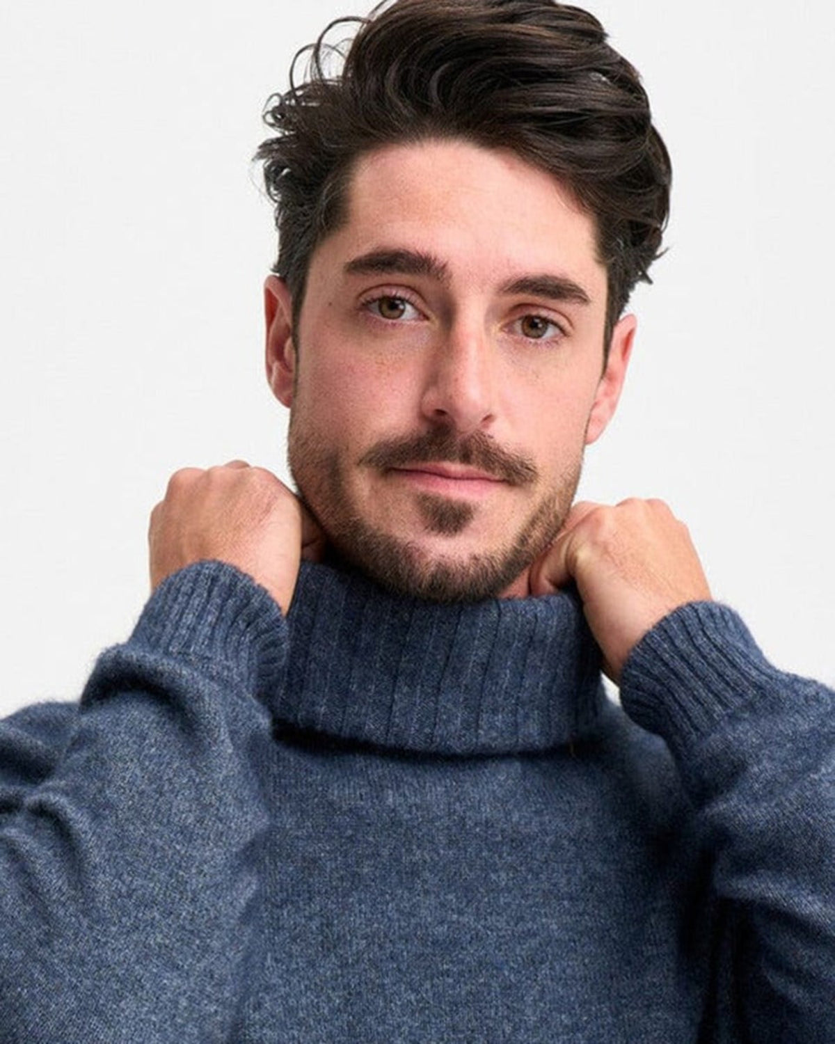 possum merino Man wearing a blue turtleneck sweater against a plain background