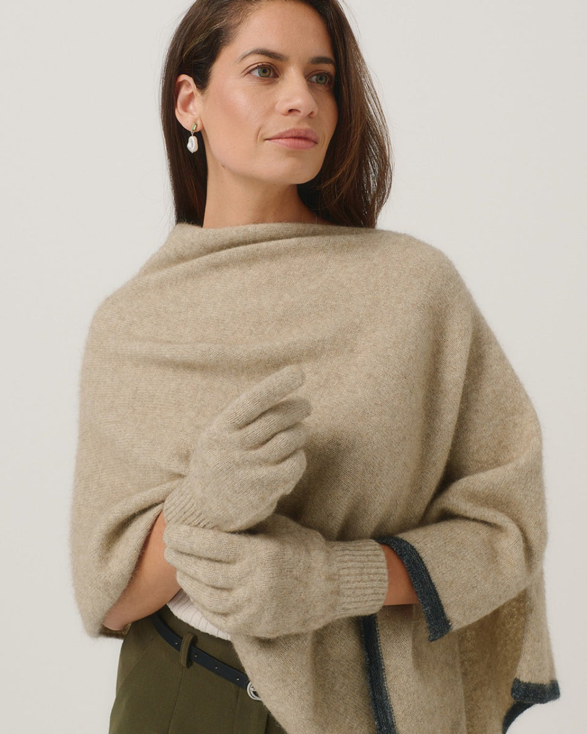 Possum merino Woman wearing a beige shawl and gloves against a white background