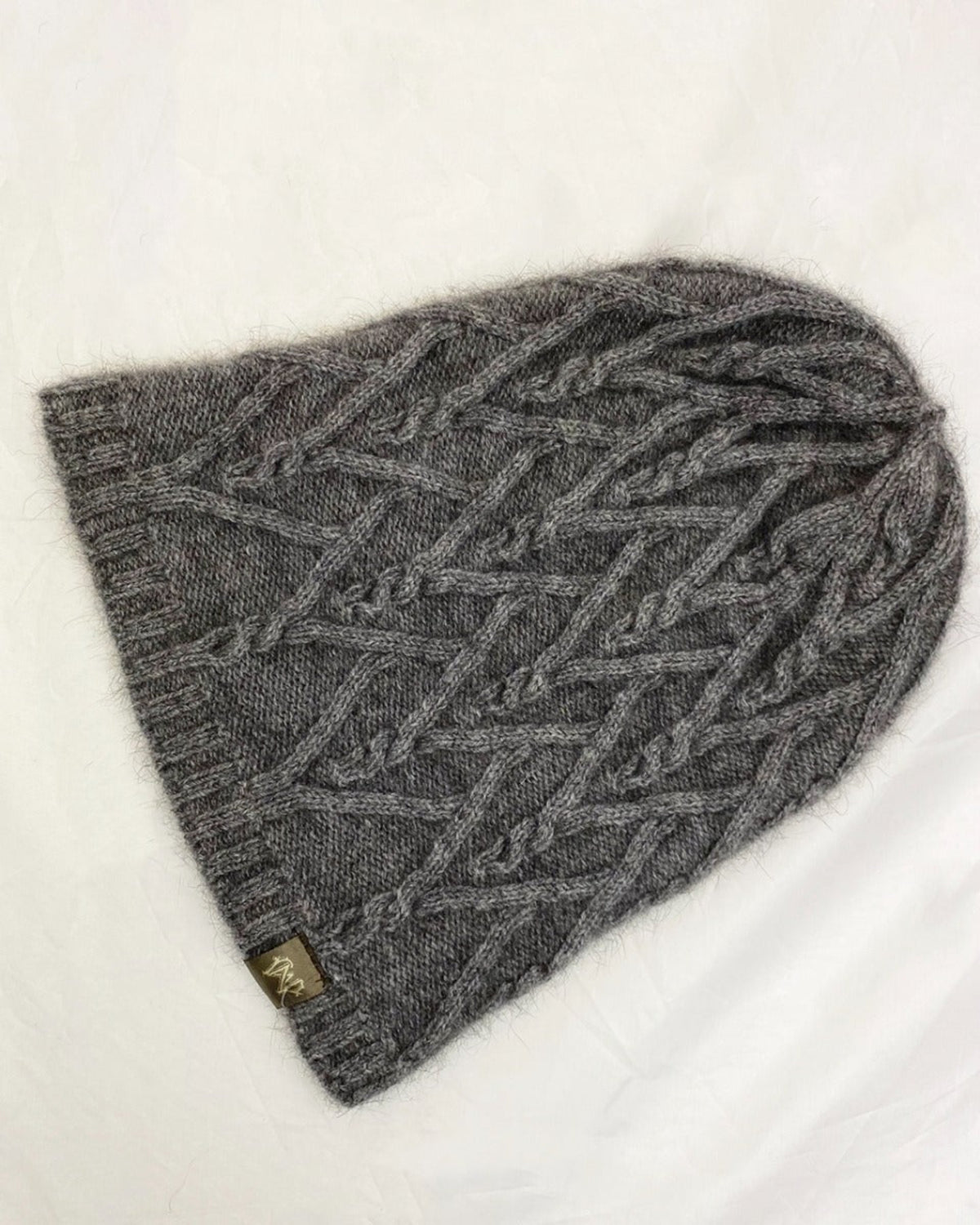 possum merino Gray knitted beanie with cable pattern on a white background
