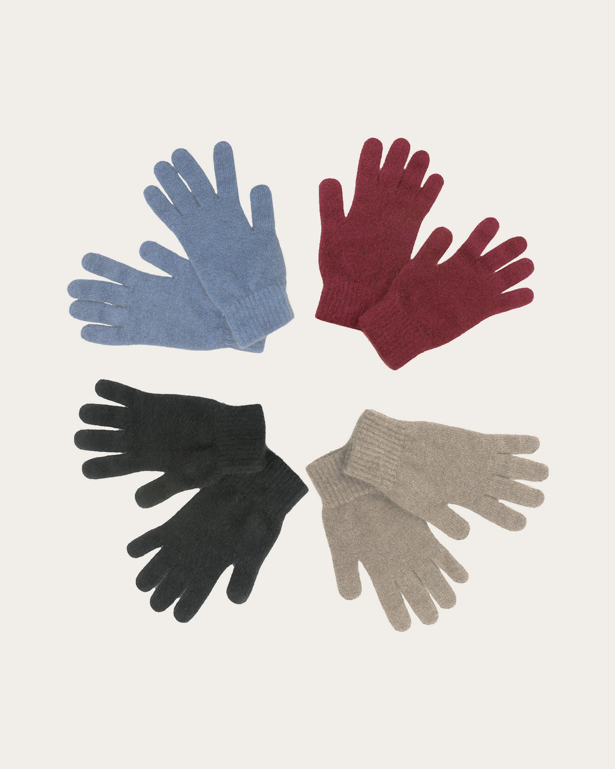 Four pairs of possum merino knit gloves arranged in a circular pattern on a light cream background. The gloves are in four colors: light blue, deep burgundy, black, and light taupe.