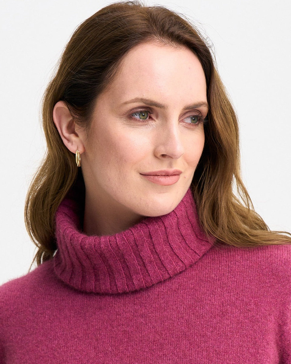 Possum merino Woman wearing a pink turtleneck sweater against a plain background