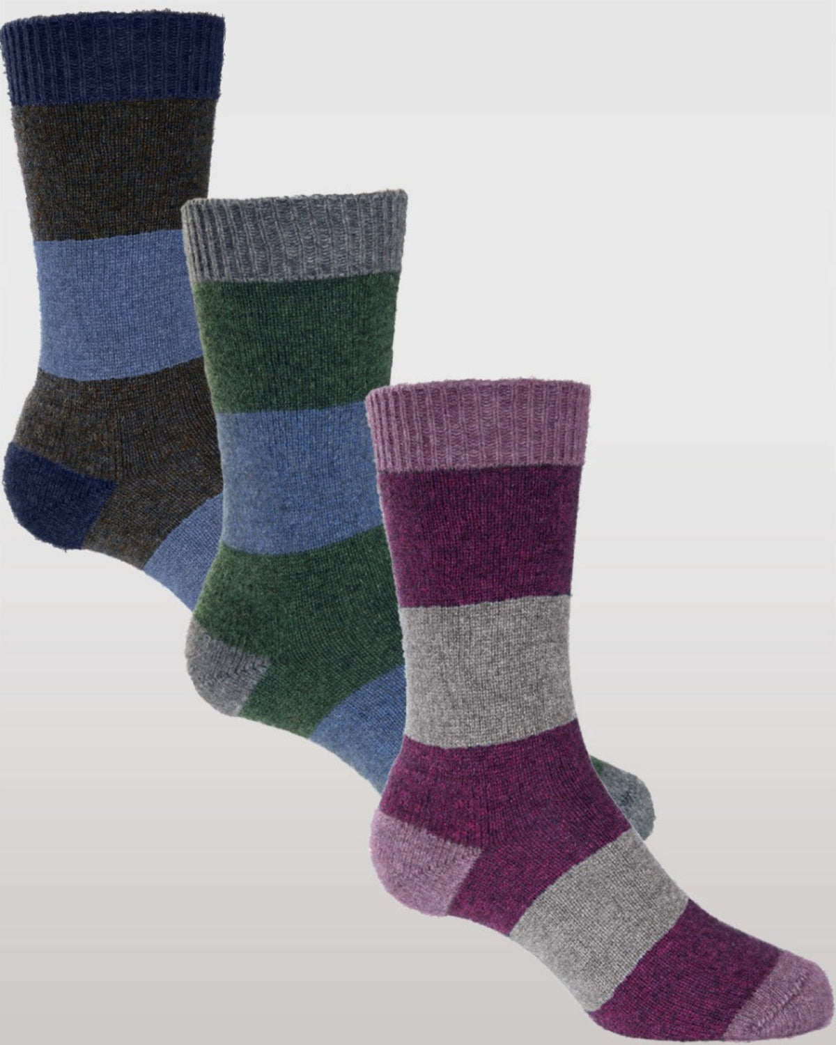 Three pairs of striped Possum Merino socks in blue, green, and purple on a light gray background