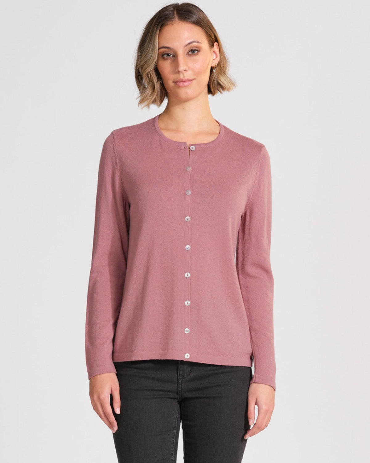 Woman wearing a merino mauve long-sleeve shirt on a white background