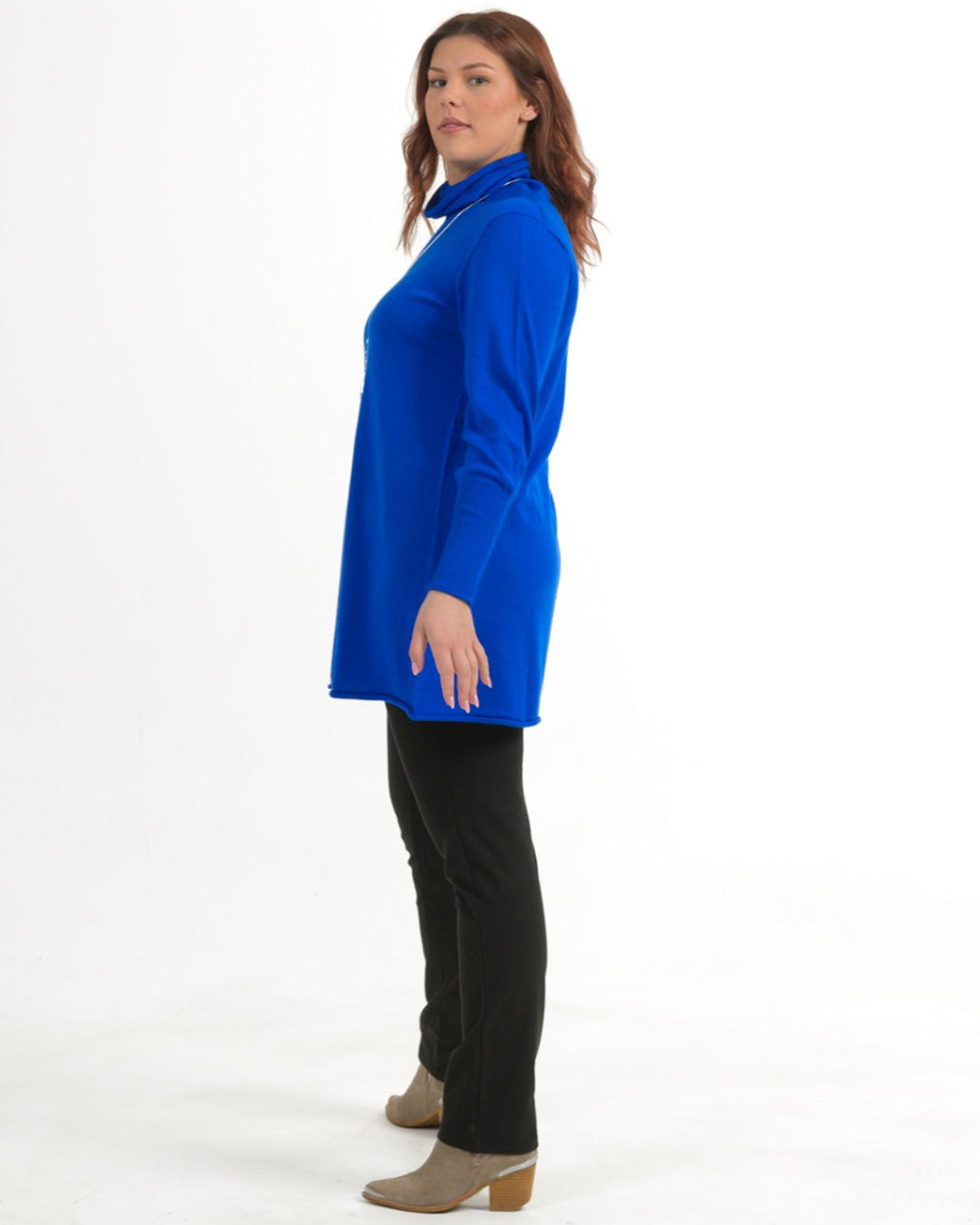Woman wearing a merino blue long-sleeve top and black pants on a white background
