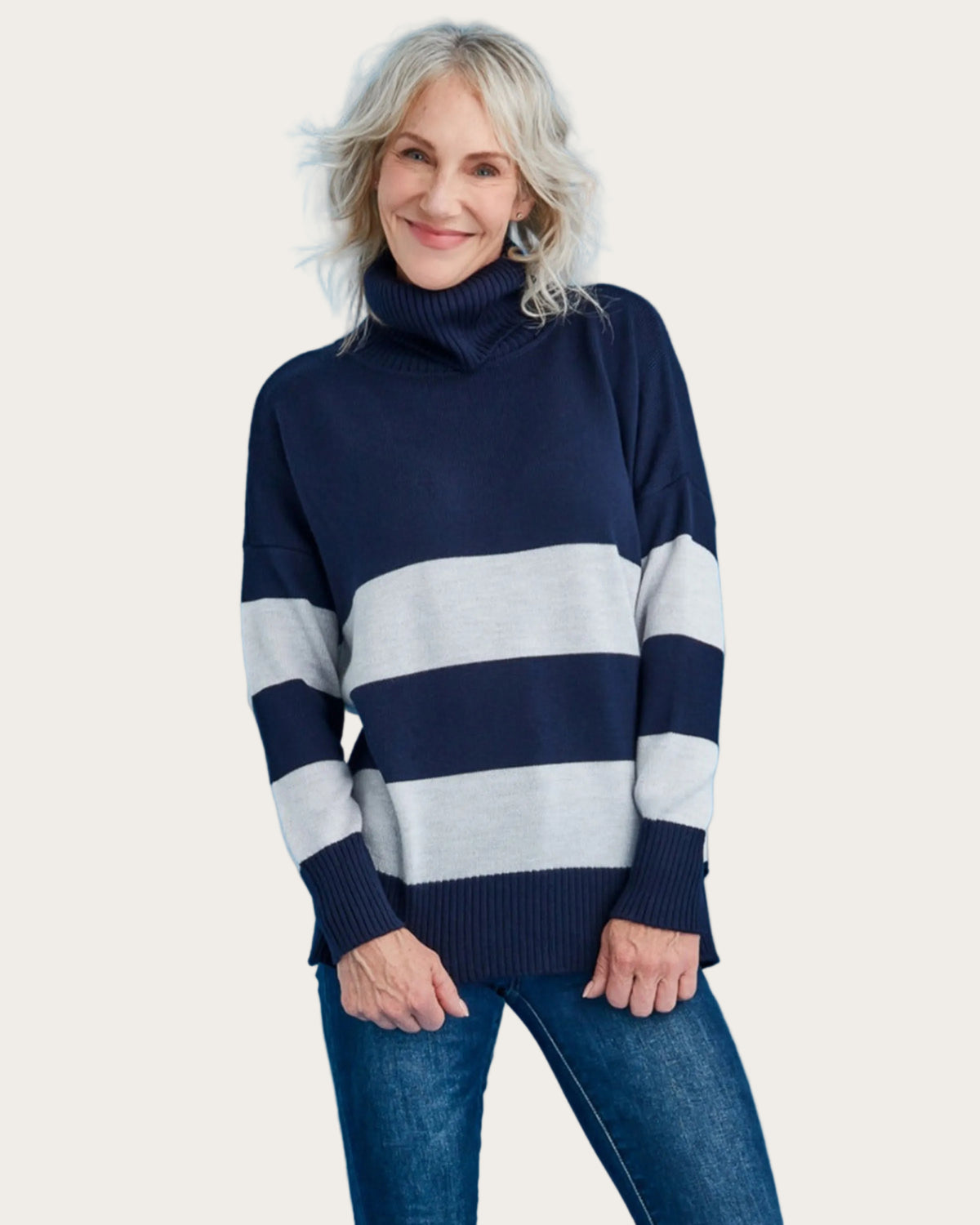 Woman wearing a merino navy and white striped sweater against a blue background