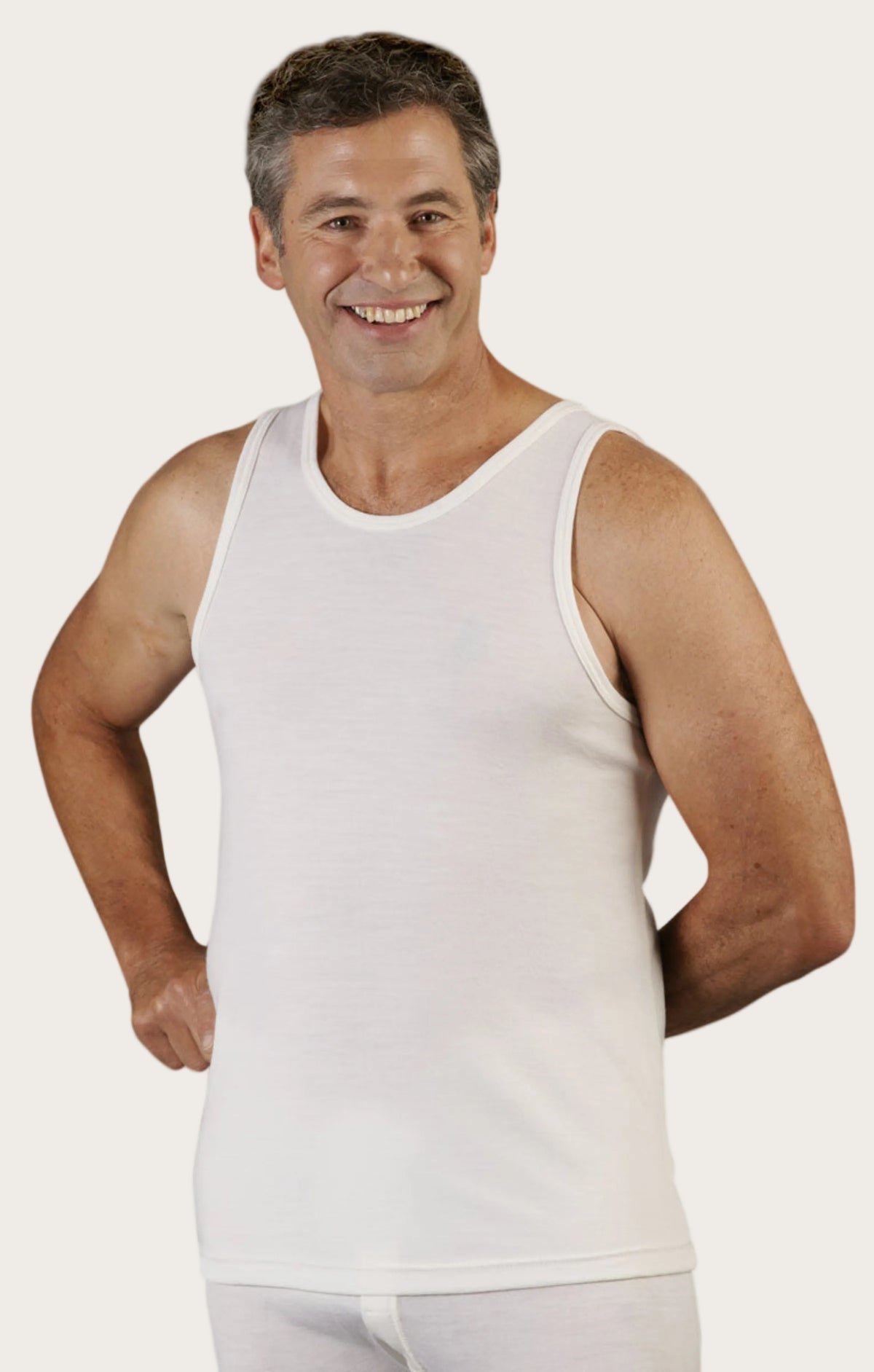 Man wearing a superfine merino white tank top and underwear on a white background