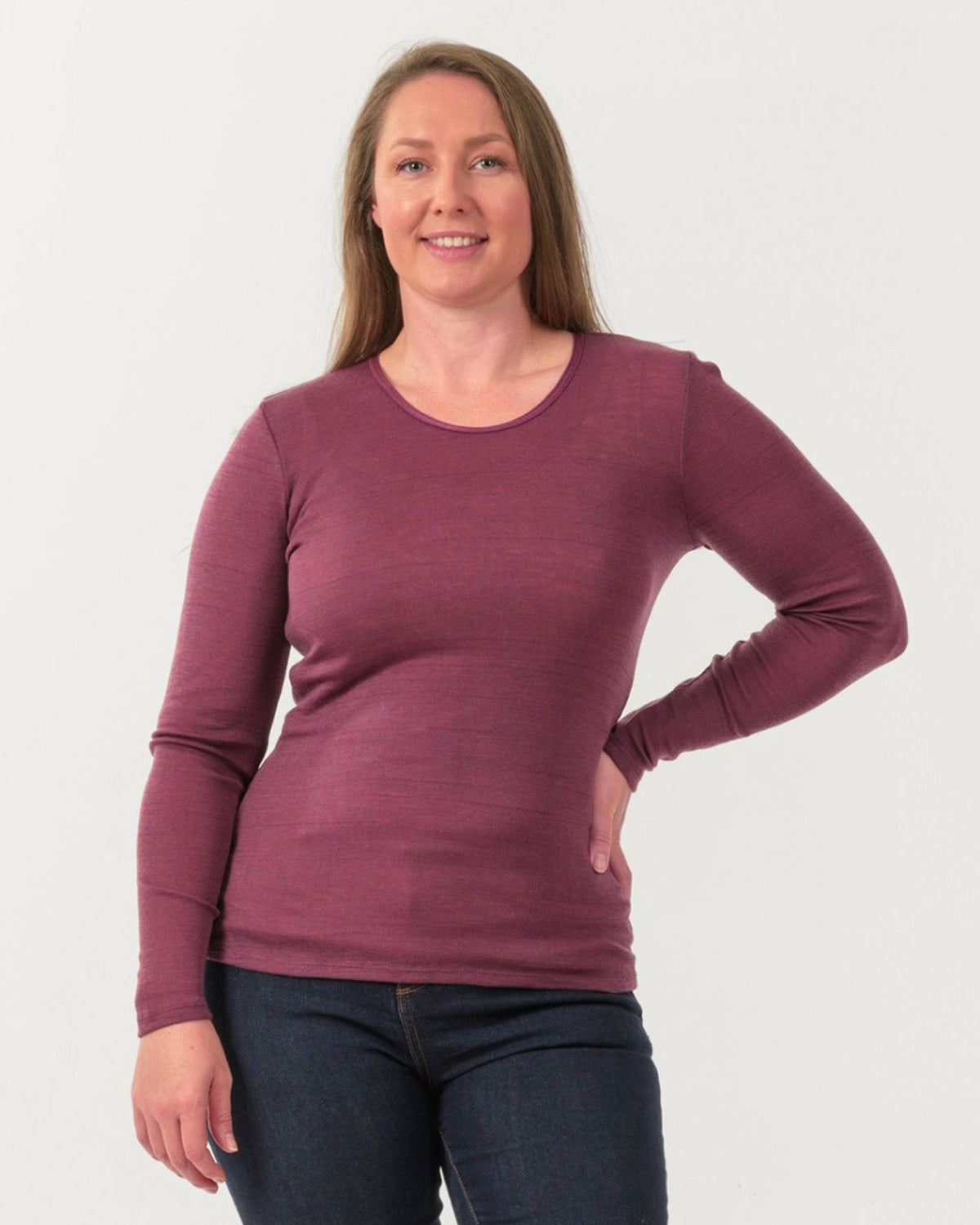 Woman wearing a merino maroon long-sleeve shirt against a white background