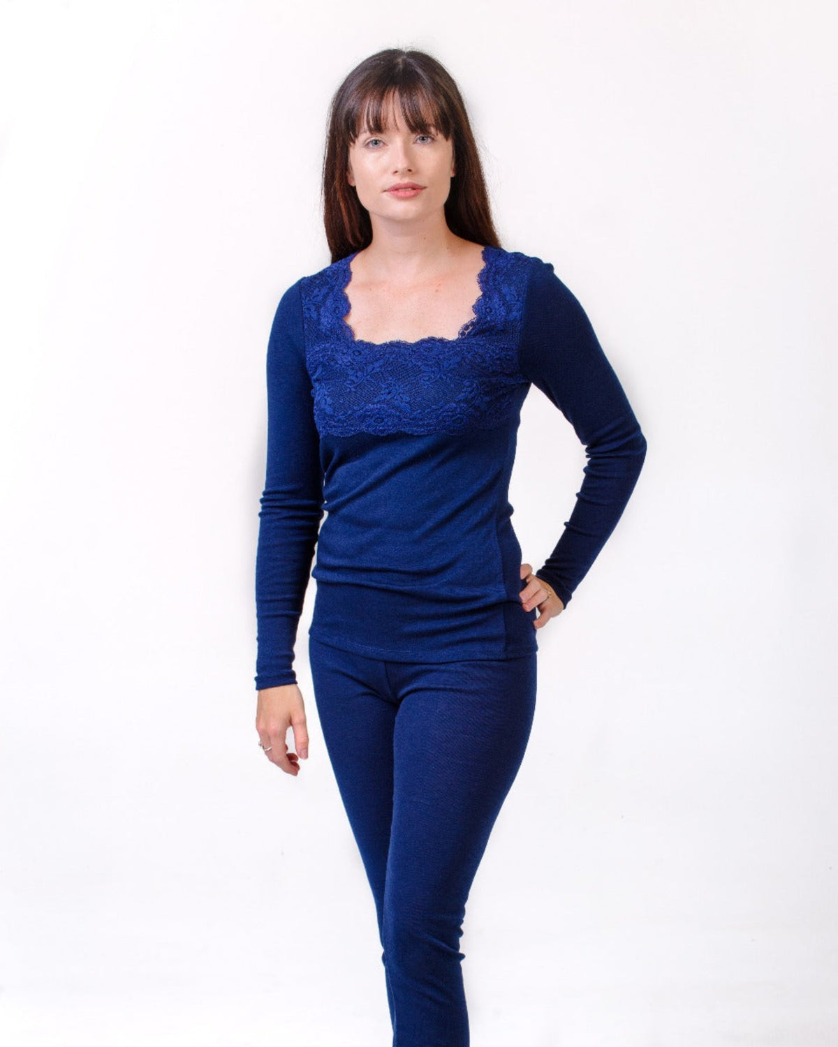 merino Woman wearing a blue lace top and pants on a white background