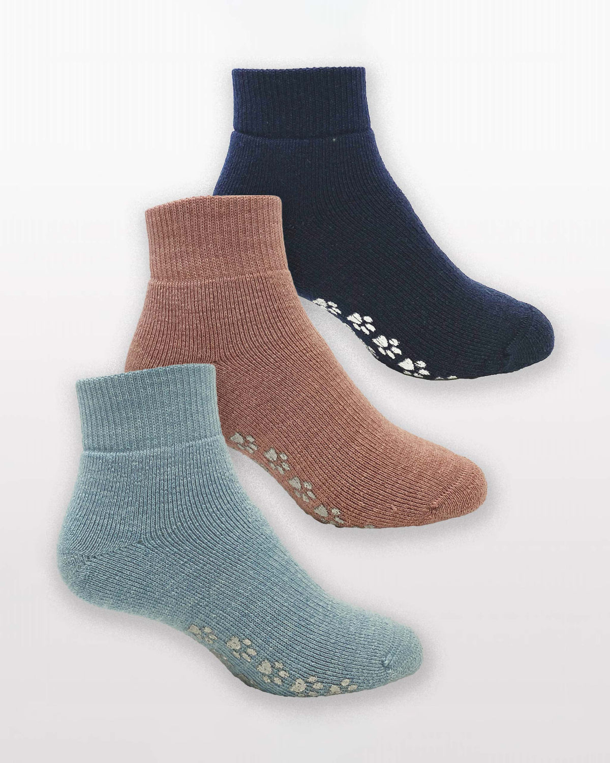 Three Merino wool ankle socks in light blue, dusty rose, and navy blue, arranged diagonally on a light gray background. Each sock features textured grip dots on the sole and paw print details near the toe.