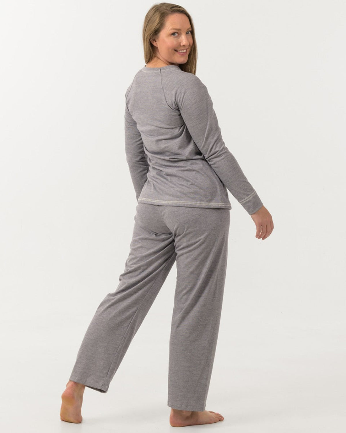 Woman wearing merino cotton a gray long-sleeve top and pants on a white background