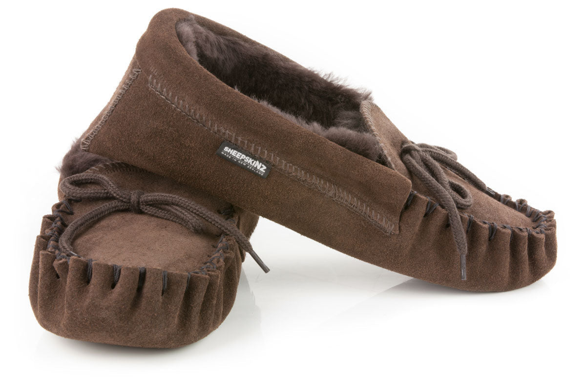 sheepskin Pair of brown moccasin slippers on a white background