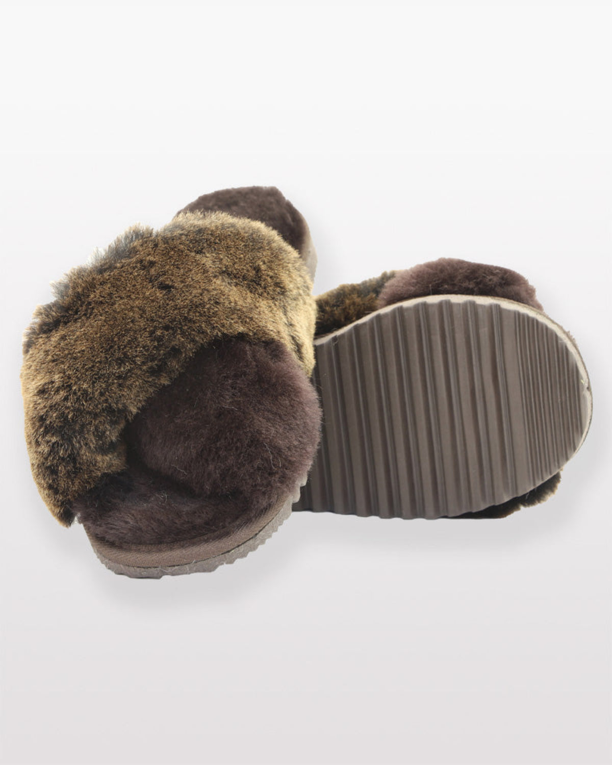 sheepskin crossover slippersPair of brown slippers with fuzzy texture on a white background