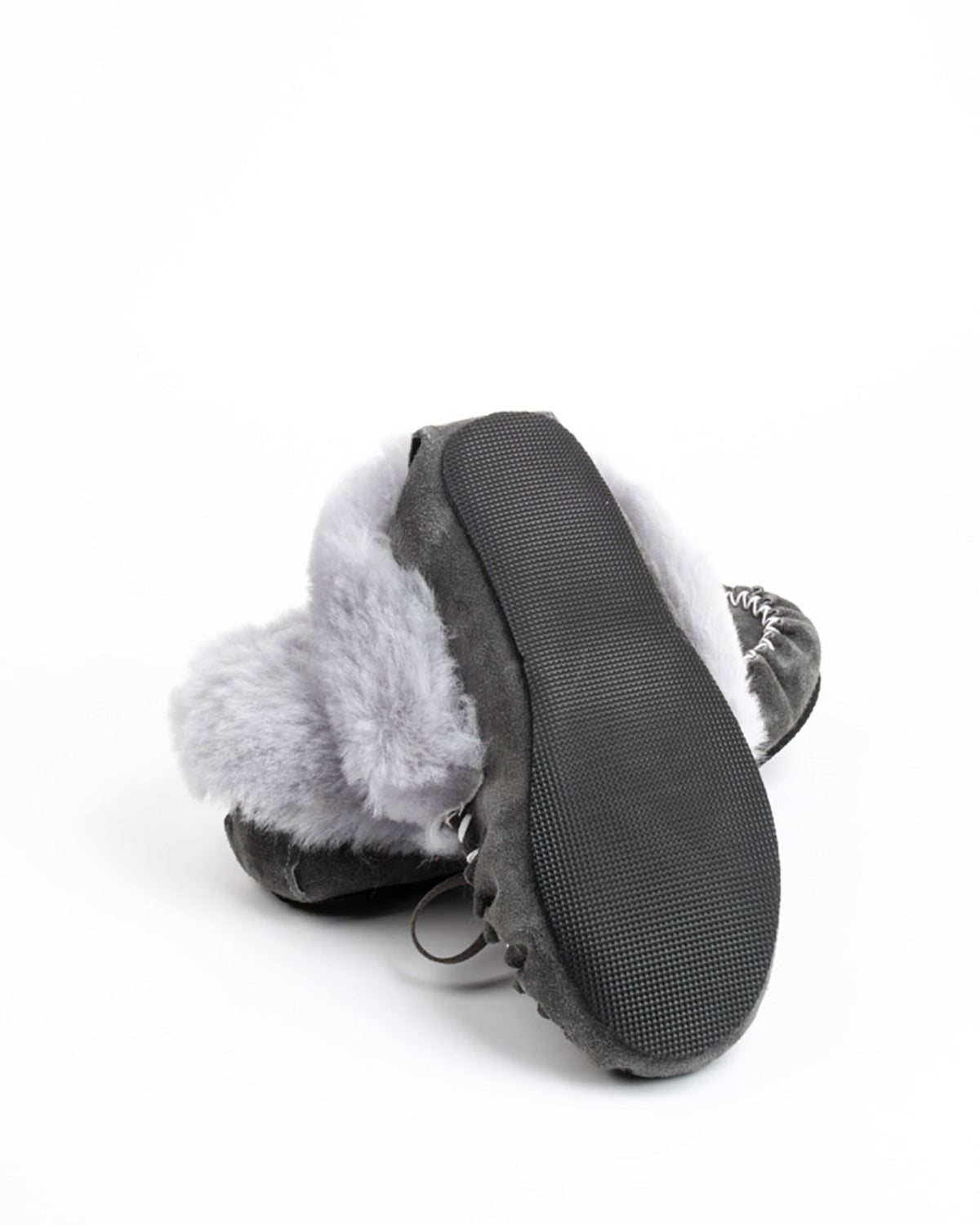 A pair of black and gray sheepskin slippers with fluffy light gray faux fur trim, shown from a top-down angle on a white background.