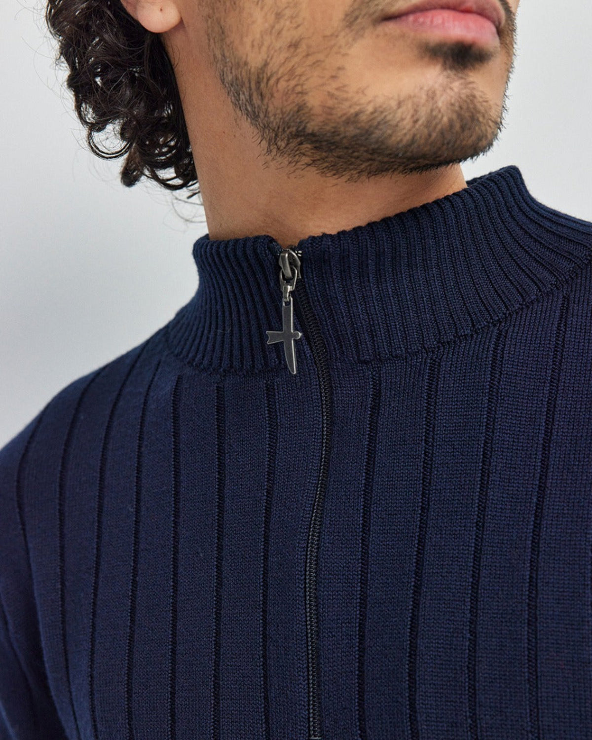 Navy blue merino ribbed sweater with a zipper detail on a plain background