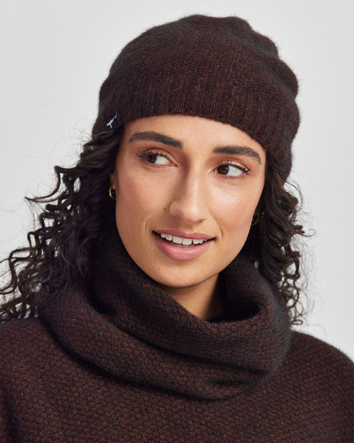 Possum merino Woman wearing a brown knit beanie and scarf on a white background
