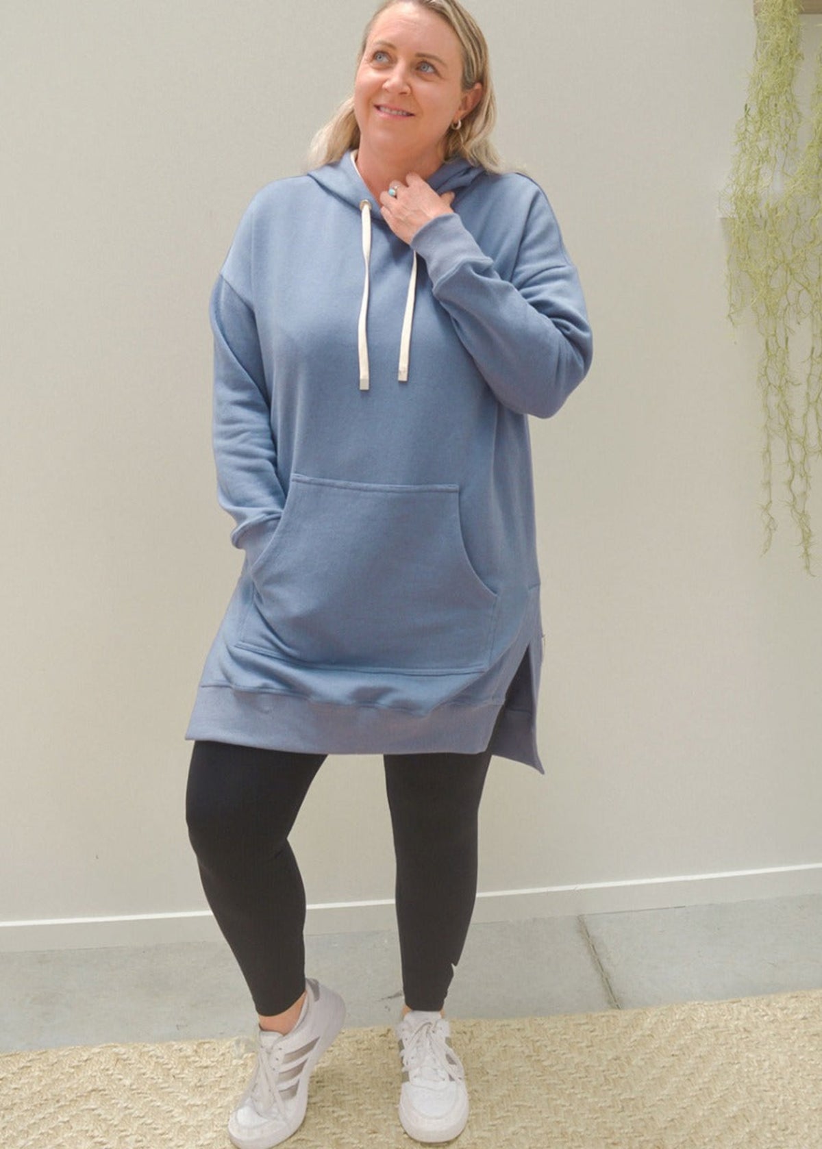 Woman wearing a blue  cosie up hoodie 