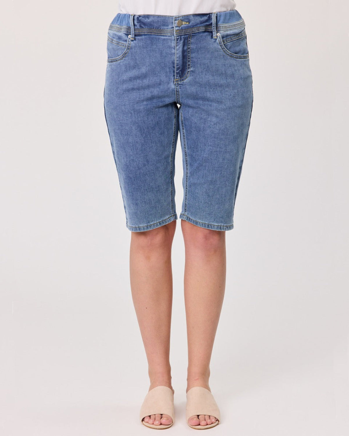 Blue denim shorts worn by a person on a white background