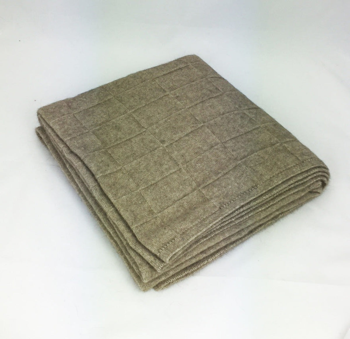 possum merino basket weave Folded brown blanket on a white background
