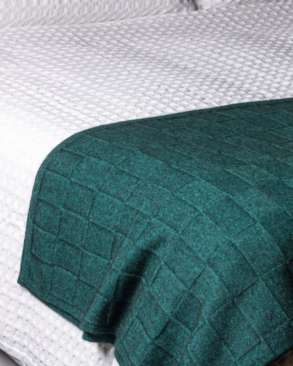 possum merino basket weave Green quilted cover on a textured surface