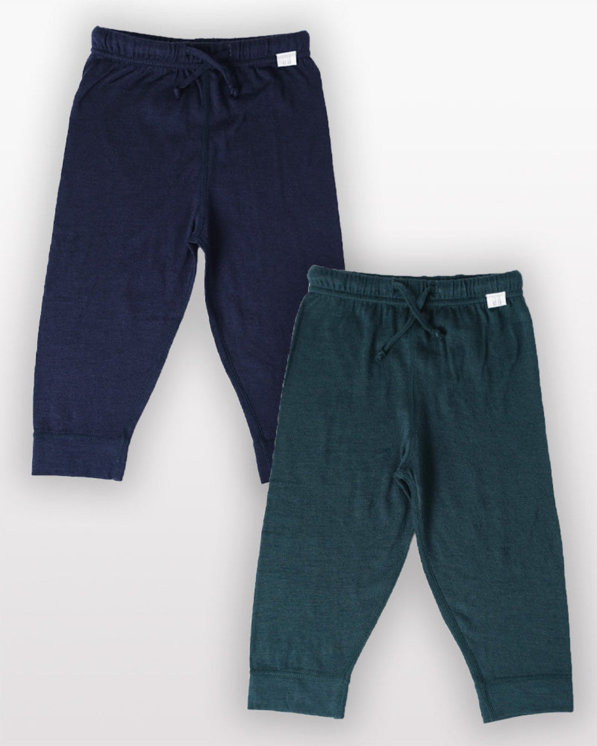 Two pairs of merino navy and green jogger pants on a white background