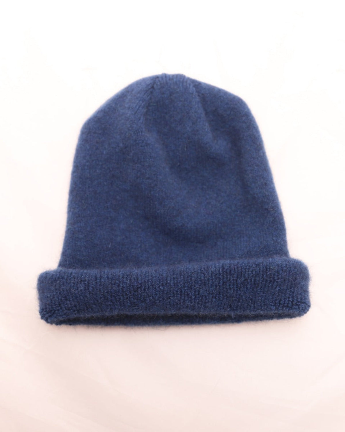 possum merino children Blue knit beanie on a light beige background