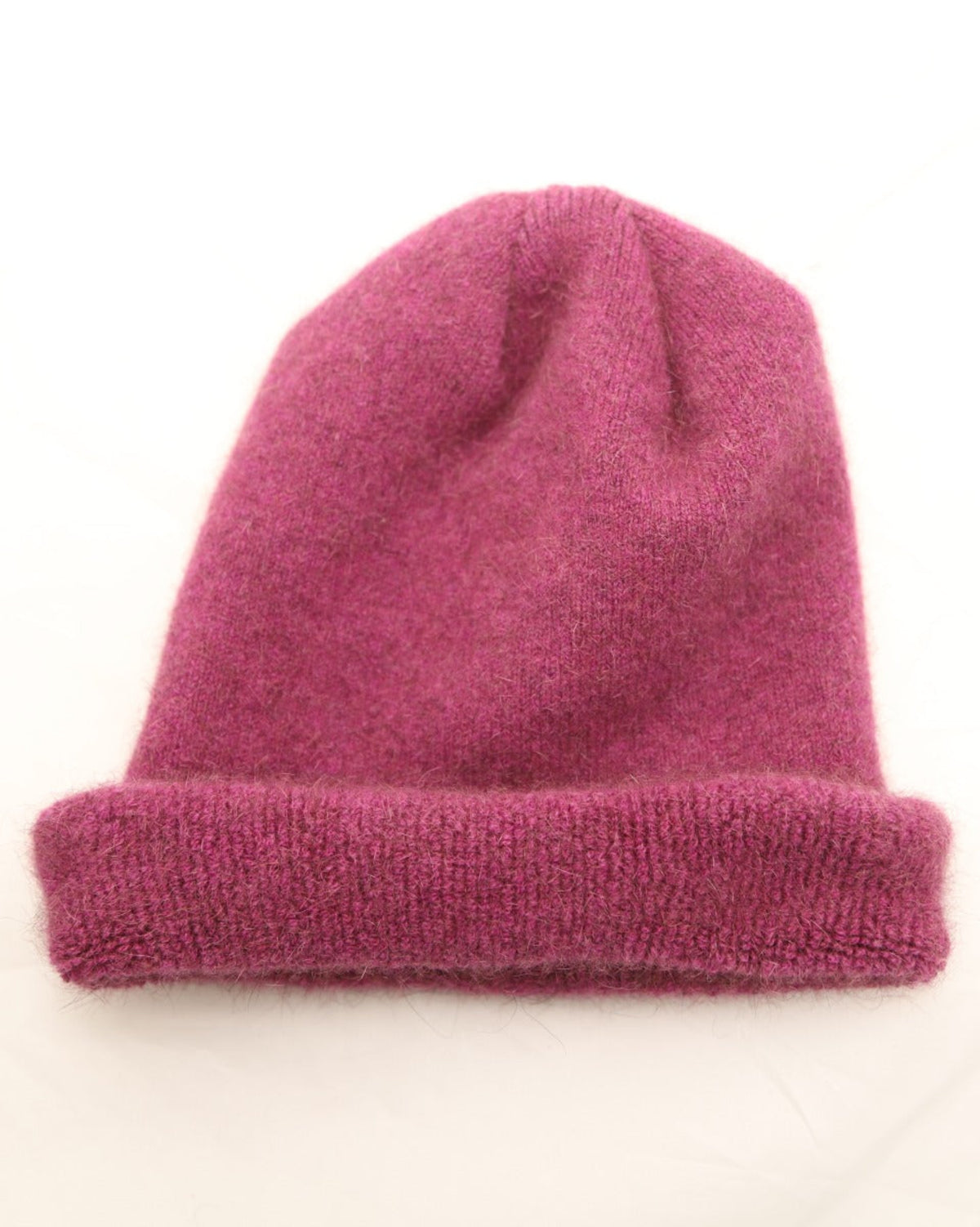 possum merino Pink knit beanie on a white background