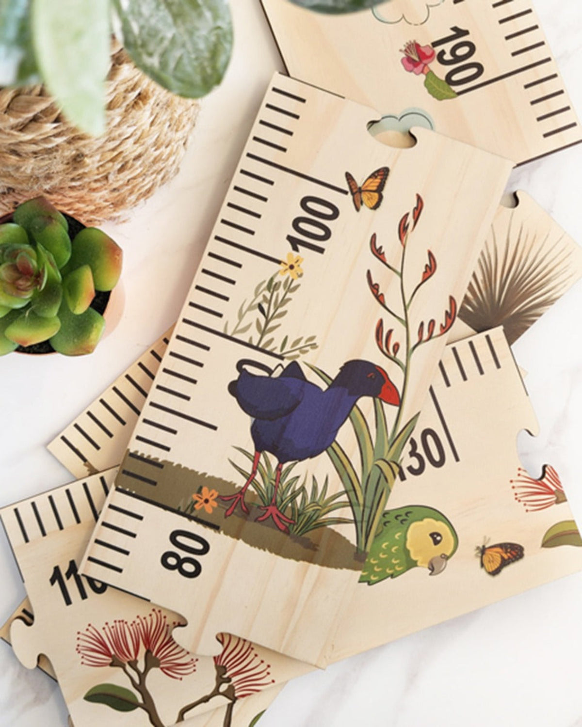 Wooden growth chart with animal illustrations on a white surface