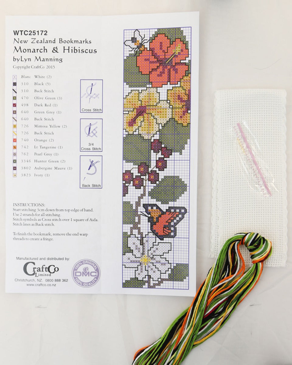 Cross-stitch kit with floral design and colorful thread on a white background