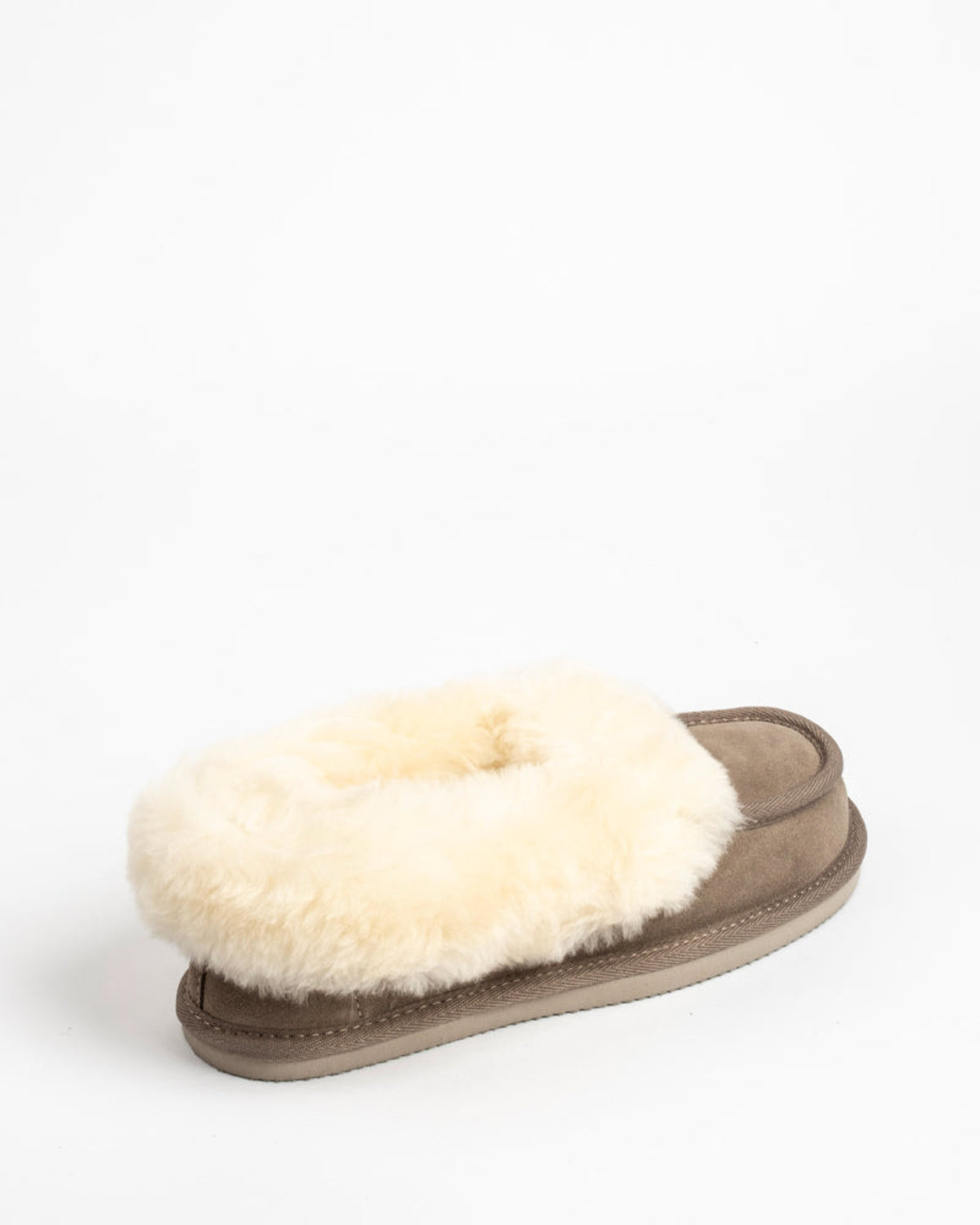 Sheepskin Slipper with white fur lining on a light gray background