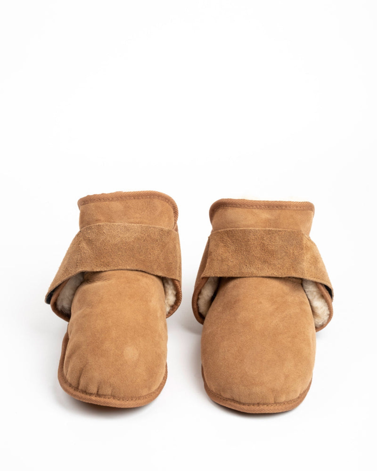 Pair of brown sheepskin adjustable slippers on a white background
